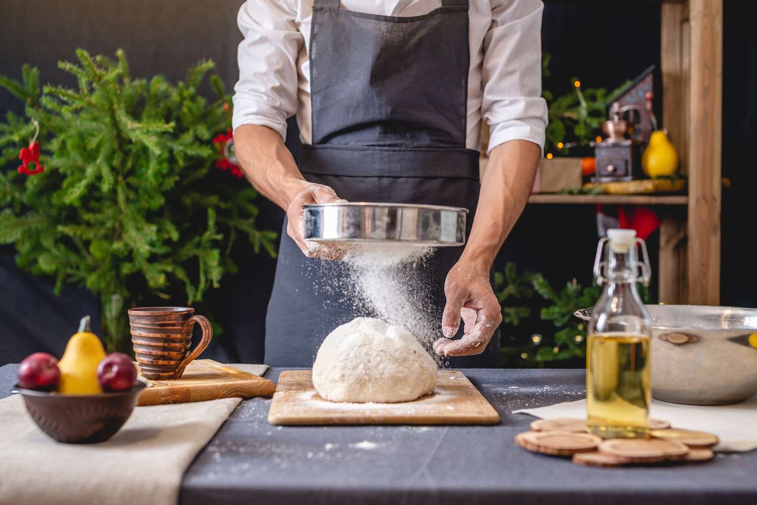 a person sifting flour on a dough