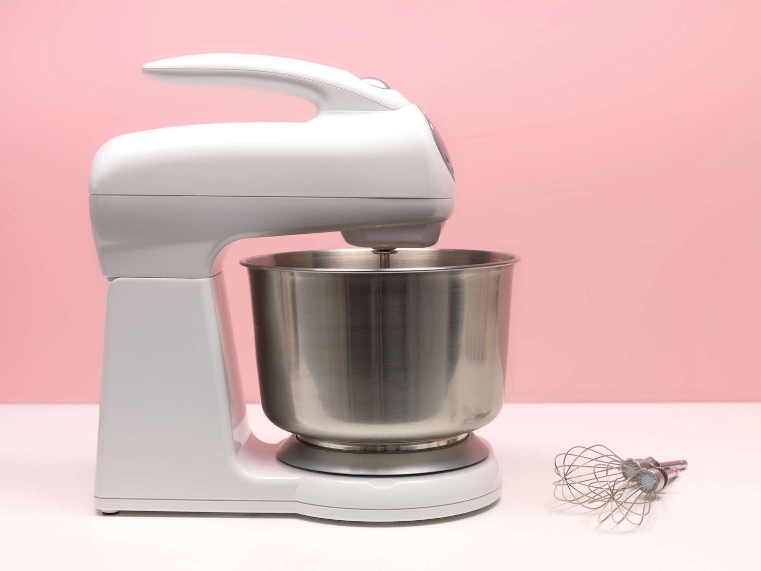 a white standmixer with a bowl and whisk