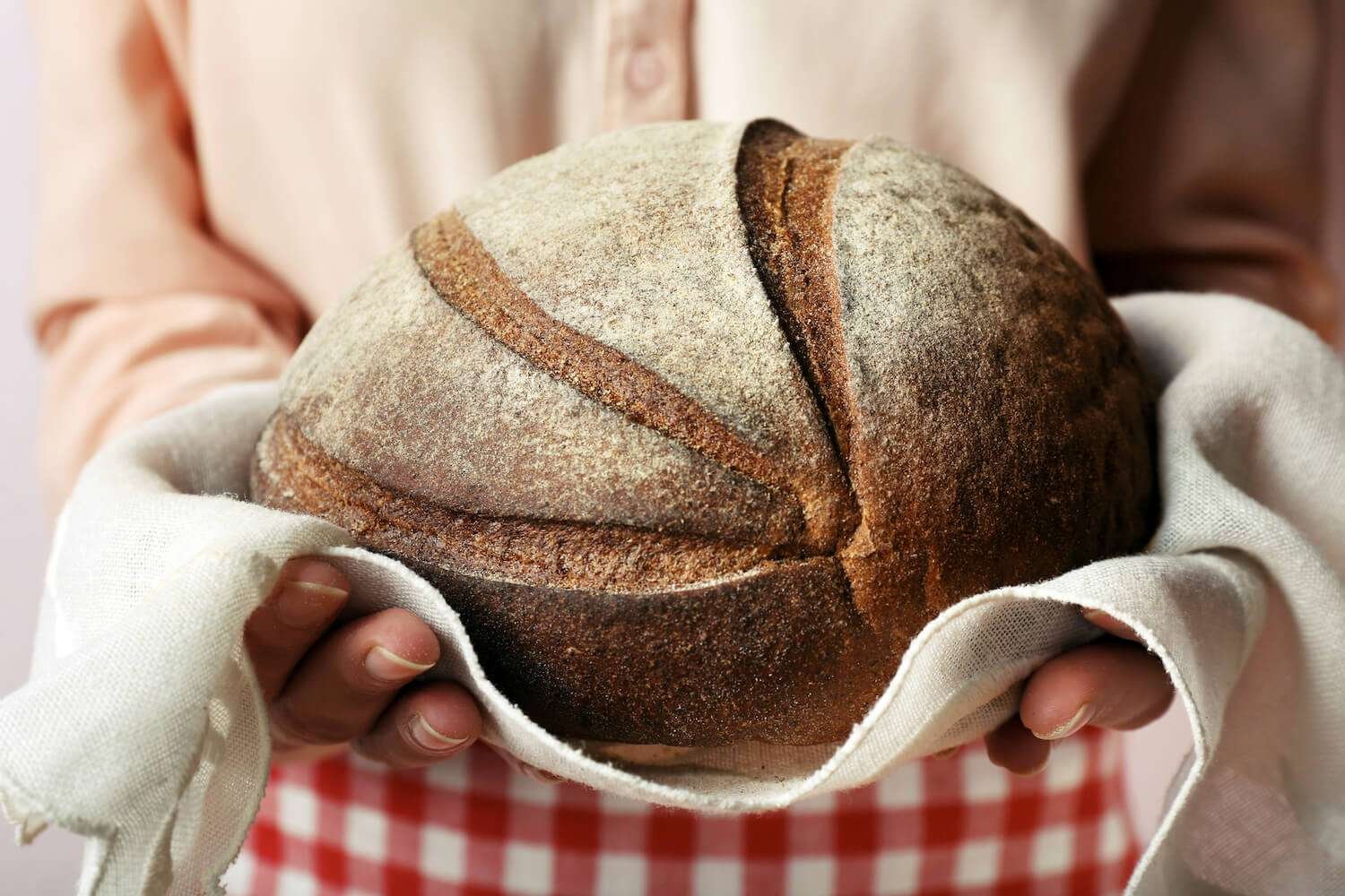 the-perfect-loaf-4 a person holding a loaf of bread