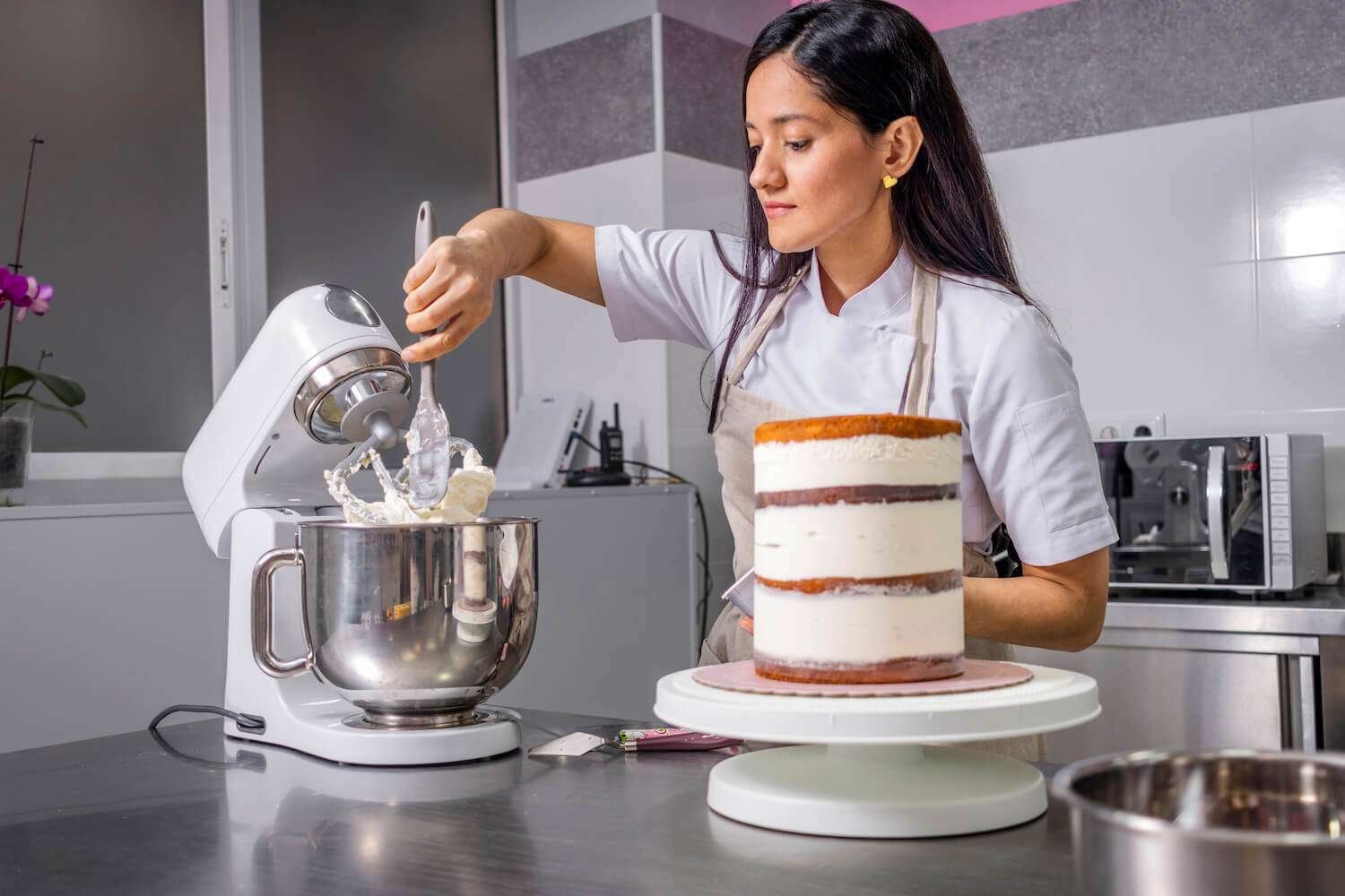 a woman in a kitchen making a cake