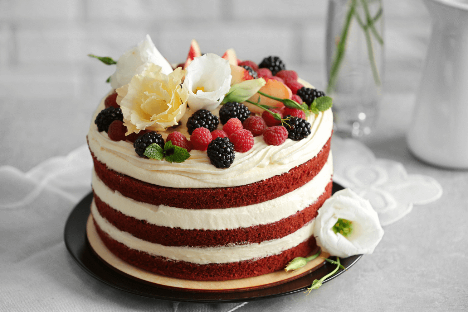 a red velvet cake with white frosting and berries
