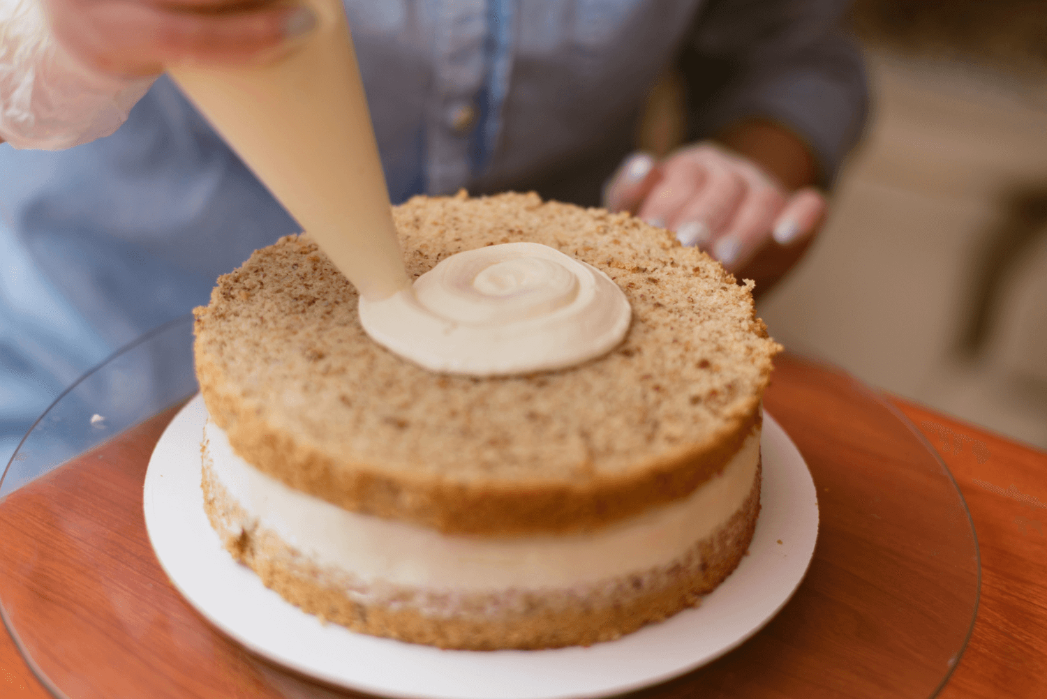 a person putting cream on a cake