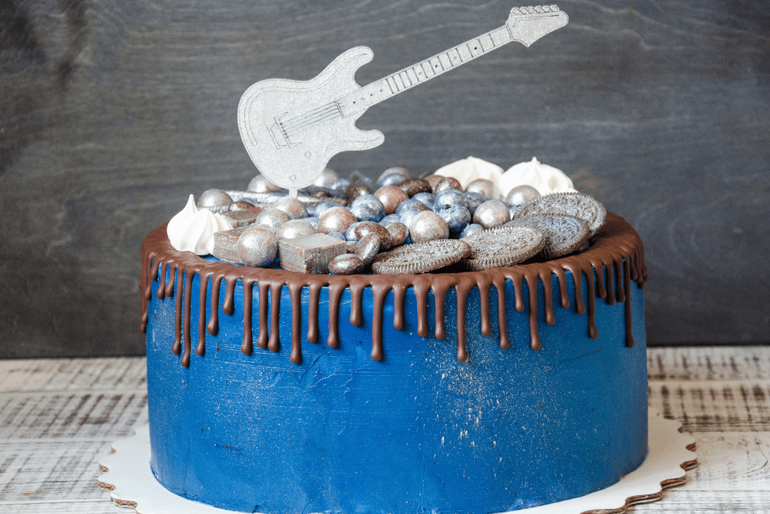 a blue music-inspired cake with a guitar on top