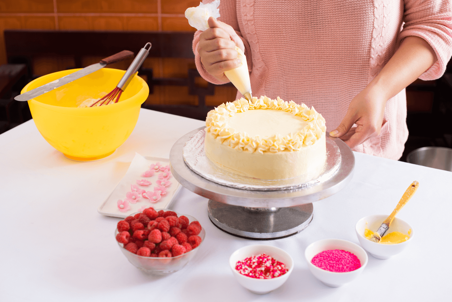 a person decorating a cake on a cake turntable