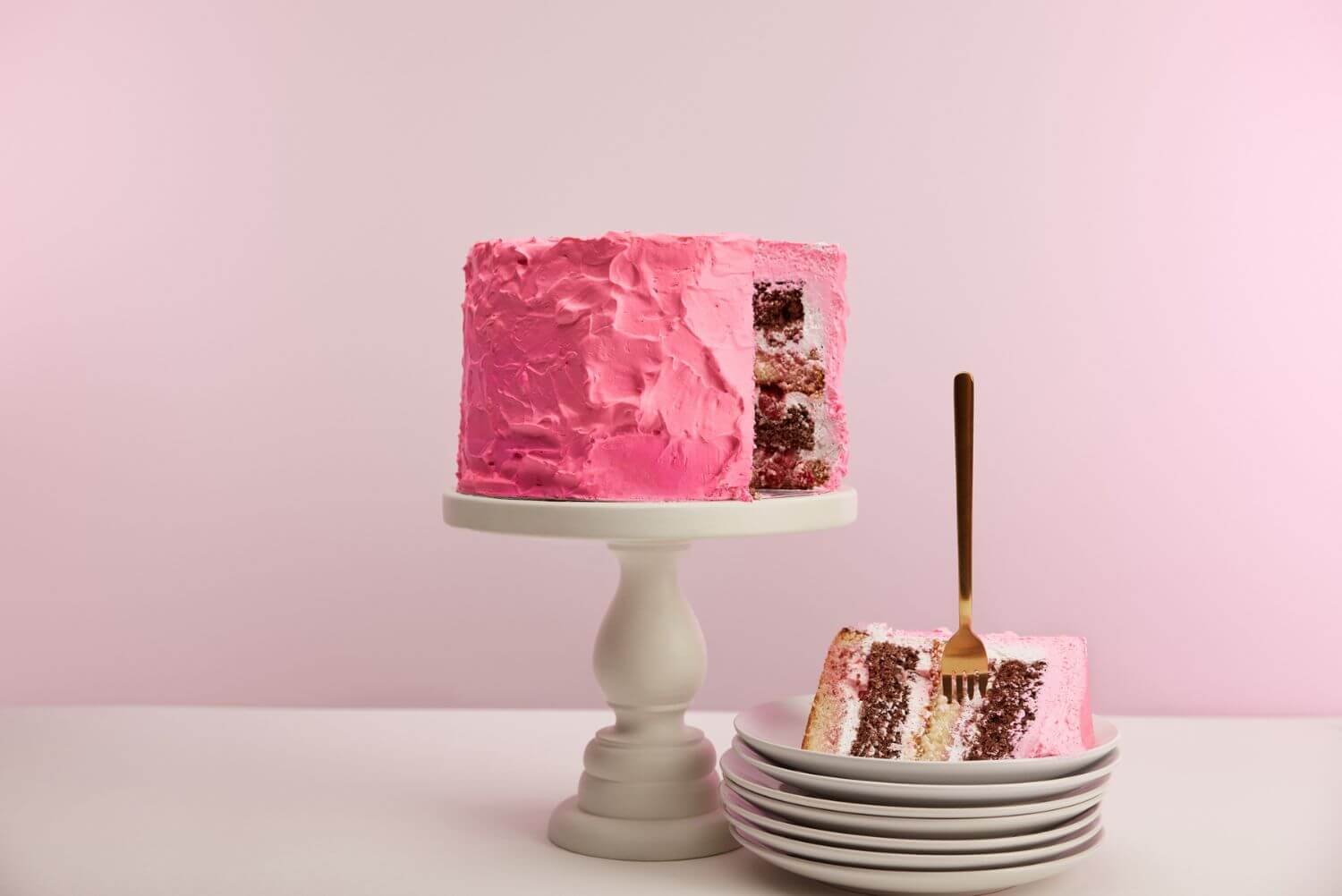 Slice of Magic: Mastering Cake Portions a pink cake with a fork on top of it
