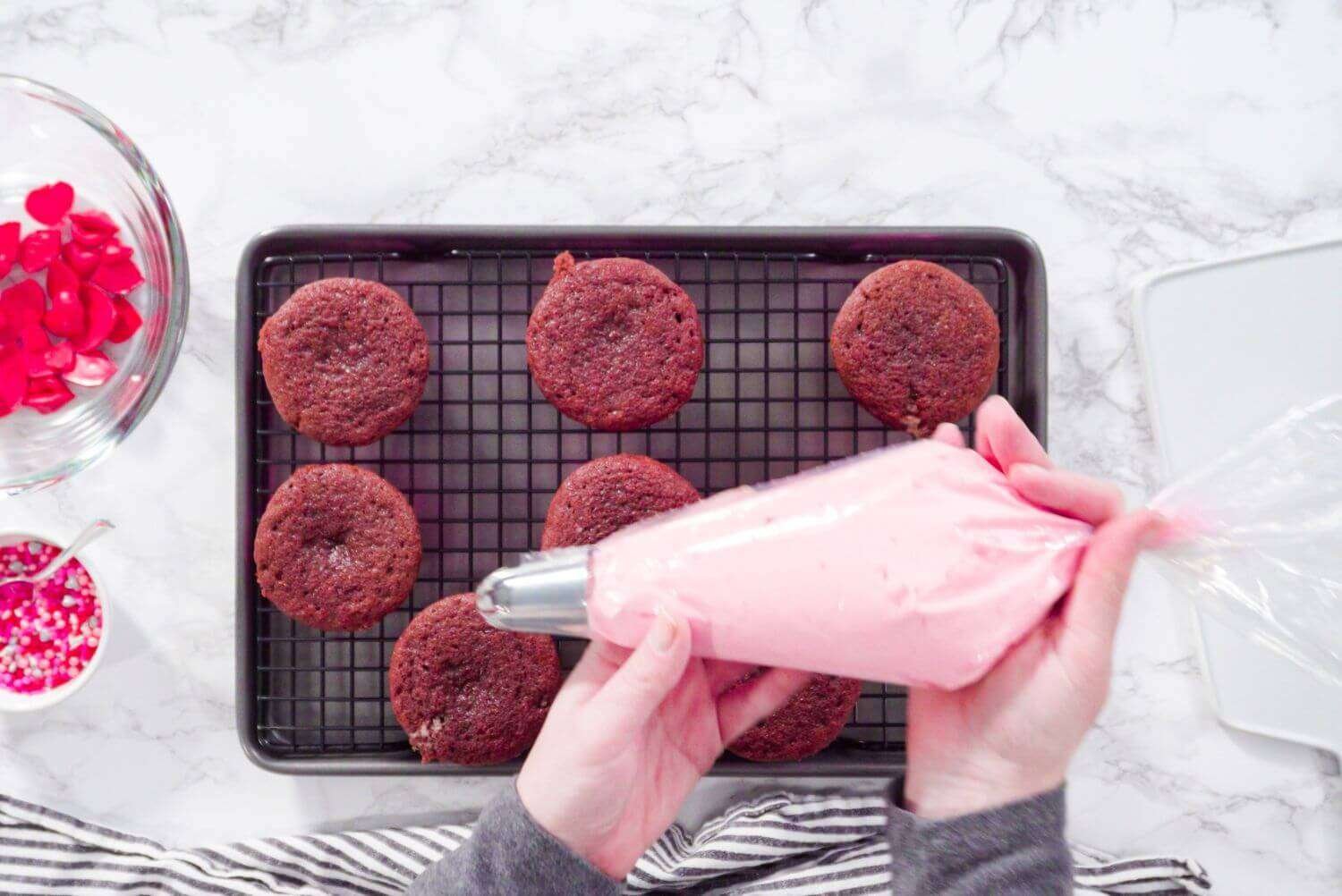 a person holding a piping bag with frosting