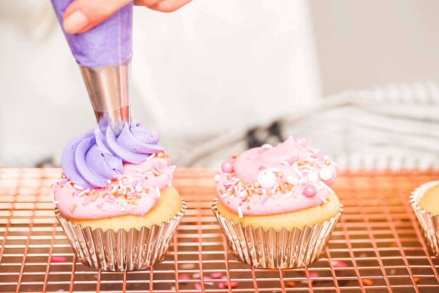 a person decorating cupcakes with frosting